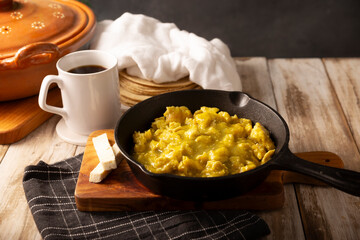 Scrambled eggs in green sauce in an cast iron skillet. A typical Mexican breakfast of scrambled eggs tossed in spicy green sauce, usually accompanied by beans and pot coffee.