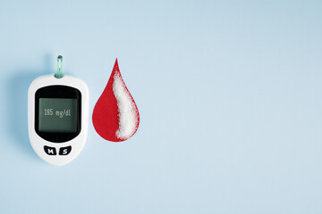 Diabetes concept blood glucose meter and drop of blood, measuring sugar level, healthcare and medical diagnosis, diabetes awareness. World diabetes day background with glucometer.