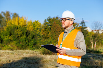Male engineer inspects the condition of a new construction site. Forestry inspector - environmental control. Conducts environmental monitoring soil analysis. Works as an ecologist. 