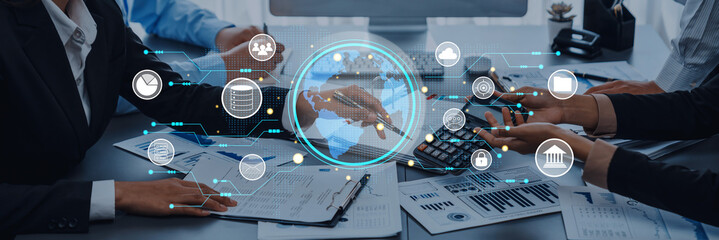 A team of professionals collaborates on financial documents while interacting with a digital interface that enhances data visualization and strategic insights in a modern office setting. Trope