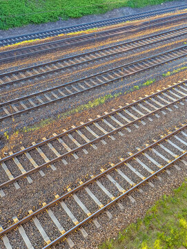 Aerial view of parallel railway tracks with wooden sleepers and metal rails creating geometric pattern perspective. High quality photograph.