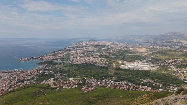 Ancient stone chapel on a coastal mountain ridge with panoramic sea view of the Dalmatian coast.