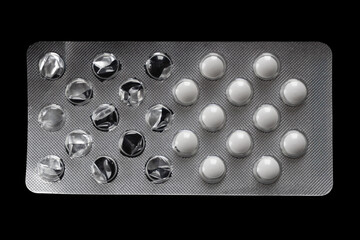 White and dark capsules in blister pack. Closeup view of prescription medication for pain relief, antibiotics, or vitamins, used in healthcare and pharmacy contexts.