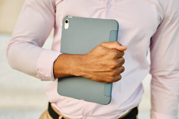 Portrait of a young  businessman wman using a tablet computer  in a city park, surrounded by modern corporate office buildings architecture