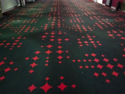 Star pattern carpet flooring with black color background for an cinema  hall at an shopping mall 