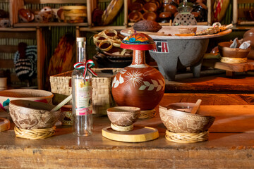 A table with a bottle of liquor and a bowl of food. The table is decorated with bowls. Historic center of Queretaro, colonial architecture, decorations for the celebration of Mexico's Independence Day