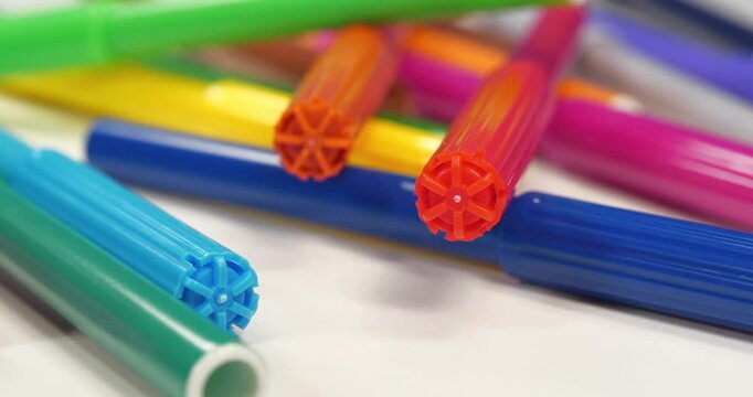 Varicolored felt-tip pens lies on the white table