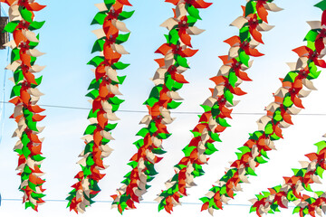 A row of colorful wind chimes hanging from a wire. The chimes are made of different colors. Historic center of Queretaro, colonial architecture, decorations for the celebration of Mexico's Independenc