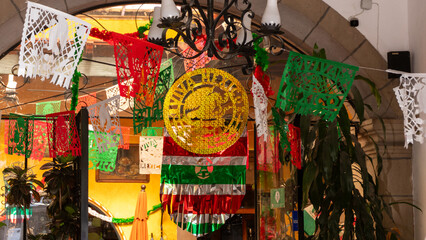 A vibrant and lively scene with a large, gold and green banner hanging in front of a building....
