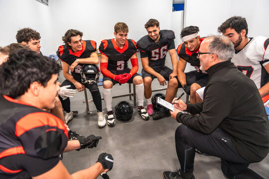 American football players and coach discussing game strategy