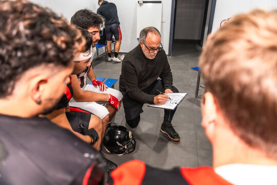 American football coach briefing team in locker room