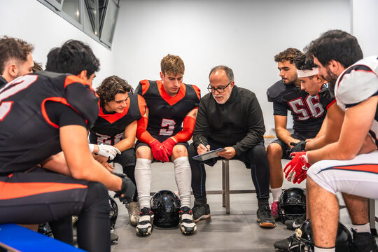 American football coach briefing team in locker room