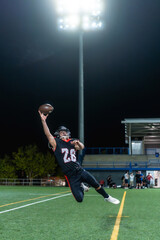 American football player catching ball during night game