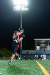 American football player catching ball during night stadium game © unai