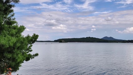 A picturesque view of a serene lake surrounded by lush greenery and majestic mountains