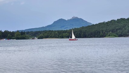 Sail on tranquil waters surrounded by stunning mountain scenery for a joyful experience