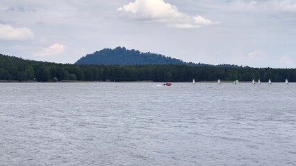 Enjoy a scenic lakeside view with sailboats set against a stunning mountain backdrop