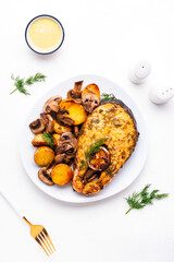 Yummy dinner with grilled salmon, baby potatoes and mushrooms with creamy garlic sauce on white table, top view