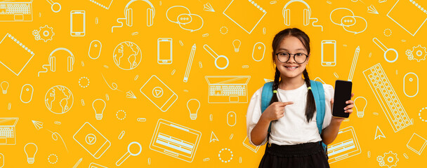 A cheerful child stands against a bright, yellow background filled with school items. She holds a...