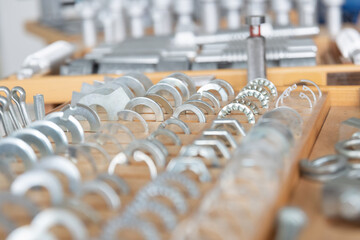 Reihen von metallischen Bauteilen sind gleichm&auml;&szlig;ig in einer Werkstatt oder Produktionsumgebung angeordnet. Das Motiv steht f&uuml;r industrielle Fertigung, Ordnung und pr&auml;zise Serienproduktion.