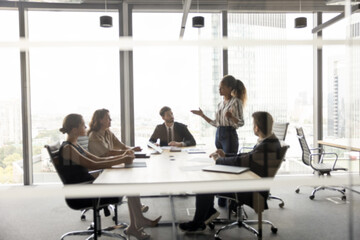 Smart young woman professional coach lead workshop for diverse businesspeople