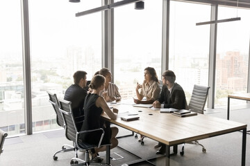 Mature female expert express idea on multicultural team meeting