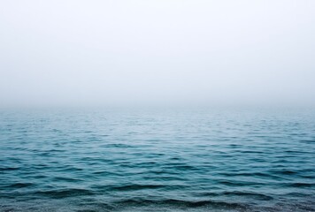 Obraz premium Calm, vast expanse of ocean meeting foggy sky, creating a serene, minimalist scene