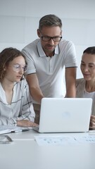 Obraz premium Business people team collaborating and analyzing data on a laptop during an office meeting, uniting efforts to reach shared objectives and drive successful outcomes together