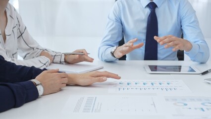 Business people reviewing financial metrics on digital screens, collaborating strategically while examining charts and graphs in office