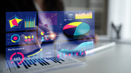A professional analyzes data with interactive graphs and charts in a modern office. The...