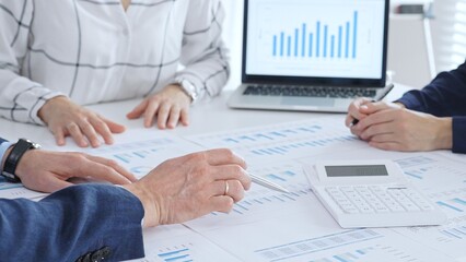 Business people analyzing financial data and market trends during a corporate meeting, collaborating on reports and planning strategic growth in modern office