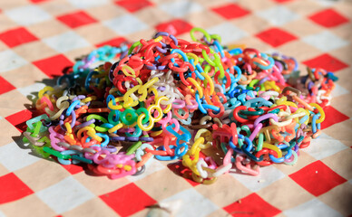 colorful plastic letters, symbols and numbers that can be connected into chains that are collected - Play Called Pebbles or Tossing And Picking Dibs