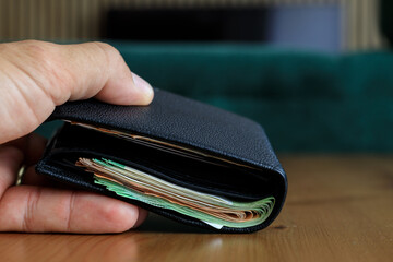 A wallet full of paper banknotes ready for a bribe when dealing with authorities as direct corruption