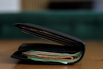 Many paper banknotes in a wallet on the table