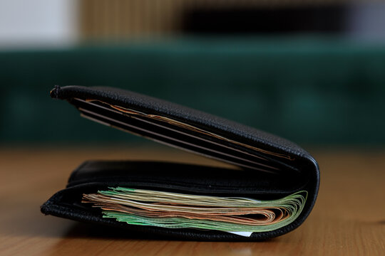 Many paper banknotes in a wallet on the table
