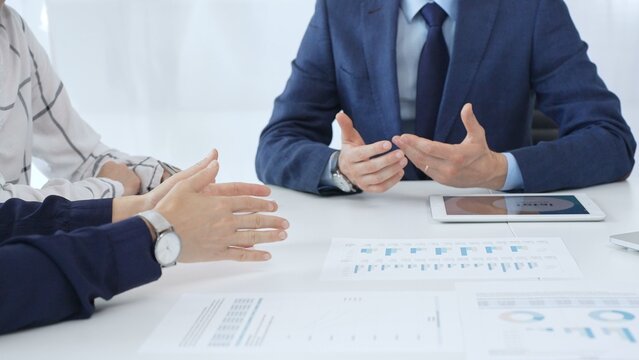 Professional team reviewing financial reports, collaborating on data analysis and strategic insights in modern corporate workspace