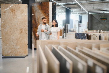 Couple choosing floor tiles for home renovation at showroom