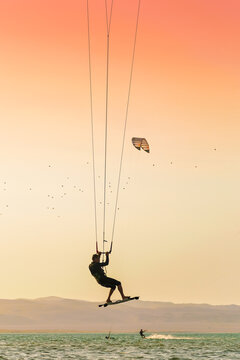 Silhouette of a kite surfing in the sea, summer at Paracas, Peru, jumping in the ocean