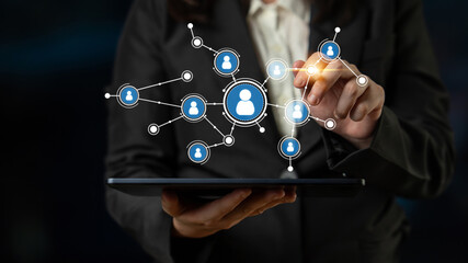 A business professional engages with a digital network on a tablet, illustrating connection and collaboration with various user icons and interactive technology elements. Tessel