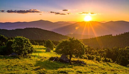 Mountainous landscape with the sun setting over green hills and valleys