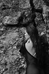 Portrait of woman in bikini on tropical beach near the mountain. Back view