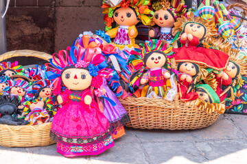 A collection of dolls with various outfits and accessories, including flowers and ribbons, are...