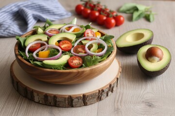A close-up shot of a fresh and vibrant avocado salad, with tomatoes and onion in a wooden bowl. The dish is presented in a way that emphasizes its freshness and healthy aspects