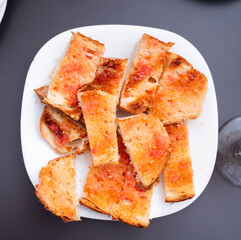 Appetizing Pan con tomate, grilled bread slices topped with mixture of grated tomatoes with garlic, spices and olive oil. Popular Catalan wine tapas