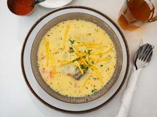 Rich traditional Bolivian peanut soup, Sopa de Mani, with tender beef, chopped vegetables, pasta and aromatic herbs topped with crispy fried potato sticks, served warm