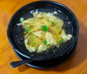 Wonton soup is cooked dumplings filled with meat or seafood. They are served in broth, usually enriched with green onions and other ingredients. Chinese cuisine
