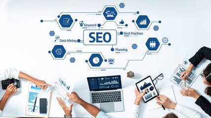 This image showcases a collaborative workspace where professionals engage in strategic SEO planning and data mining, utilizing modern tools for enhanced online visibility. Amity