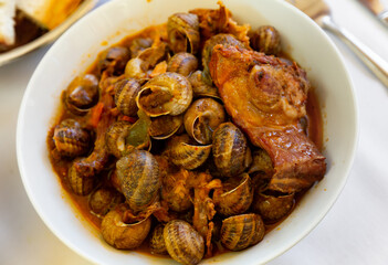 Delicious stewed snails with rabbit meat and sausages served on platter