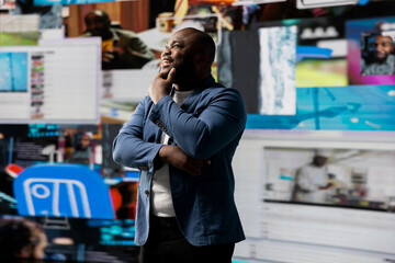 Smiling african american influencer being connected on vibrant digital interfaces and visualizations, representing mobile content creation, global reach and social network web experiences.