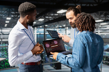 Multiethnic team worrying about compromised systems due to security breach, implementing emergency protocol to protect and save the server hub infrastructure. Malicious hacking danger.